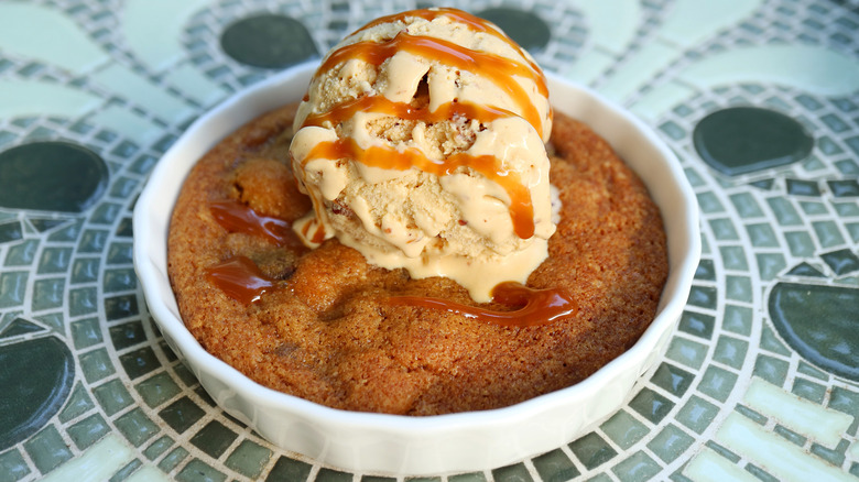 Cookie baked in a ceramic dish with a scoop of ice cream on top