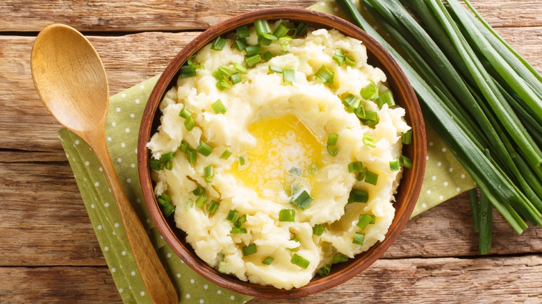 mashed potato with butter and green onions in a bowl