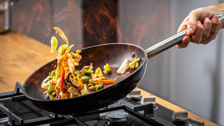 tossing food in a wok