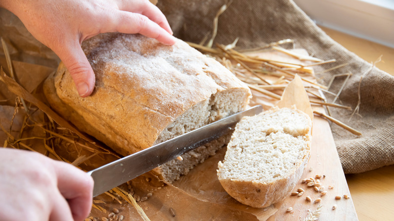 person cutting baked bread