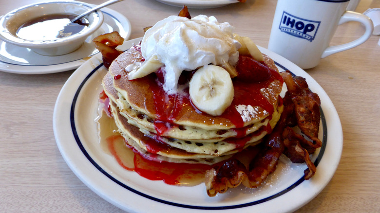 IHOP pancakes with syrup, banana, and bacon