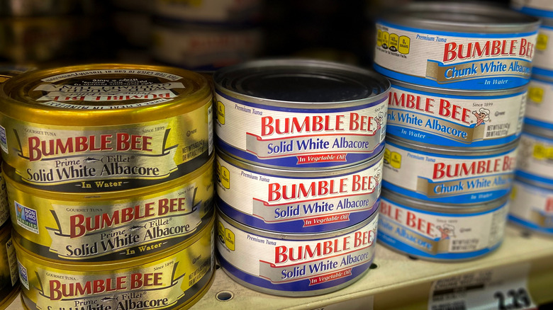 Grocery store shelf with numerous cans of Bumblebee tuna