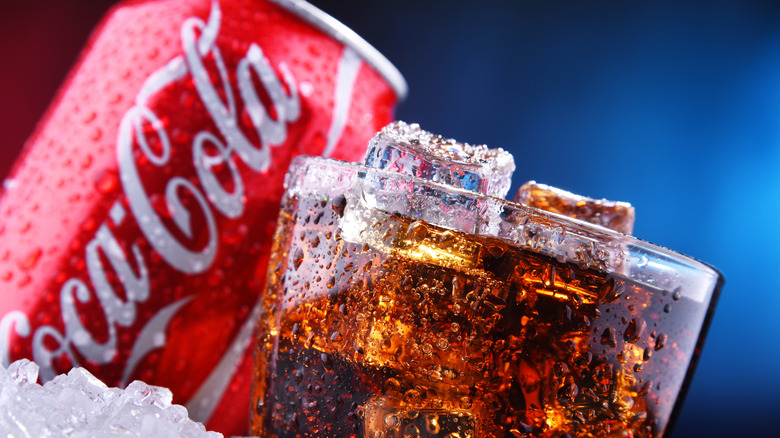 Coca-Cola in a glass with can and ice
