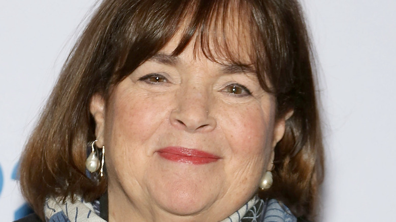 Ina Garten smiles with red lipstick and earrings