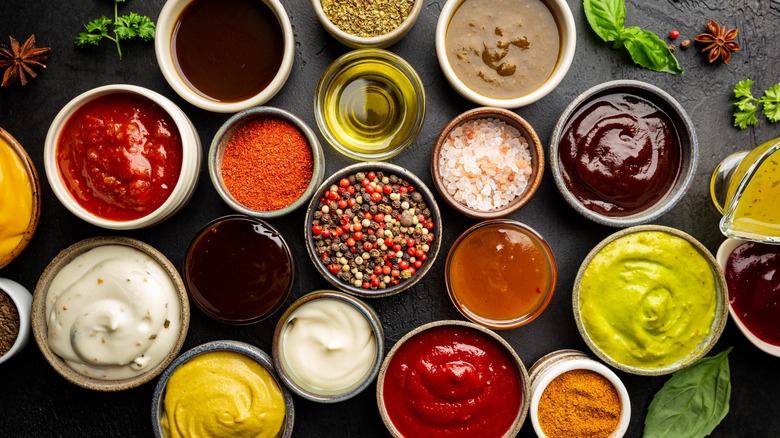 An overhead shot of a wide variety of sauces and seasonings portioned into bowls