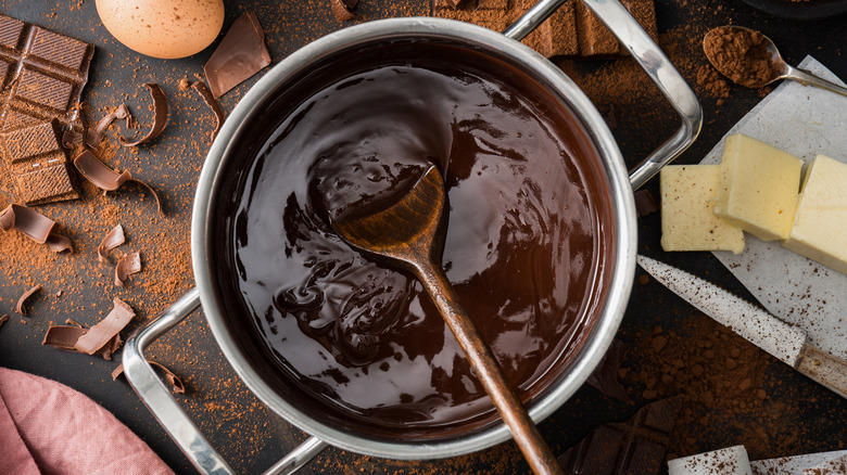 Melted chocolate in steel pot with wooden spoon