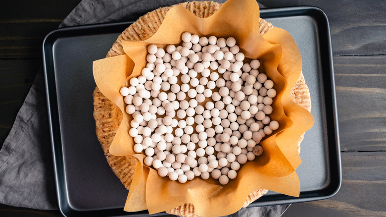 Pie weights and parchment in blind-baked pie crust