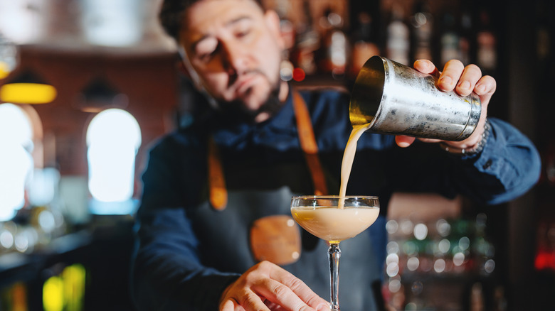 Bartender pouring a drink from a shaker
