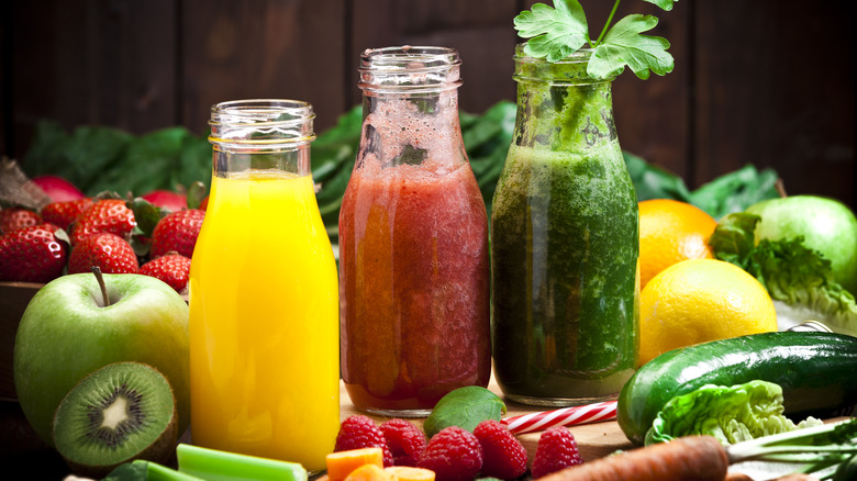 Three colorful bottles of health juices with fruits and vegetables