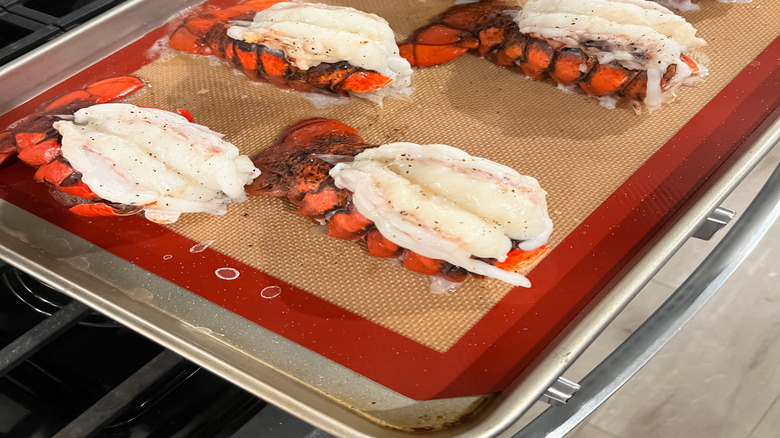 butterflied lobster tails on a baking sheet