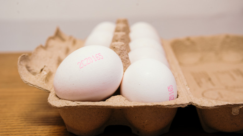 Open carton of eggs showing printed code on the side