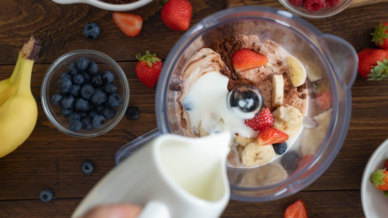 making a fruity milkshake in blender with milk