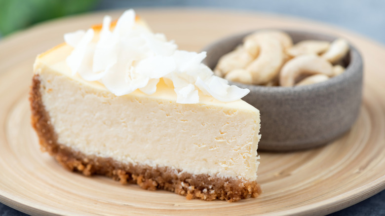 slice of vegan cheesecake with cashews and coconut flakes