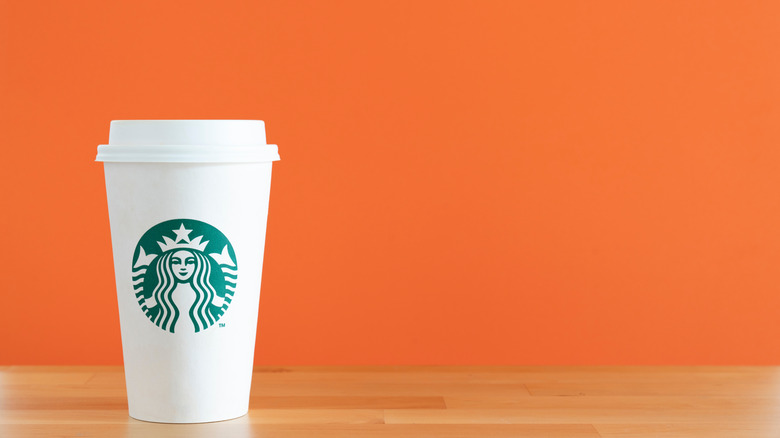 Starbucks cup against an orange background