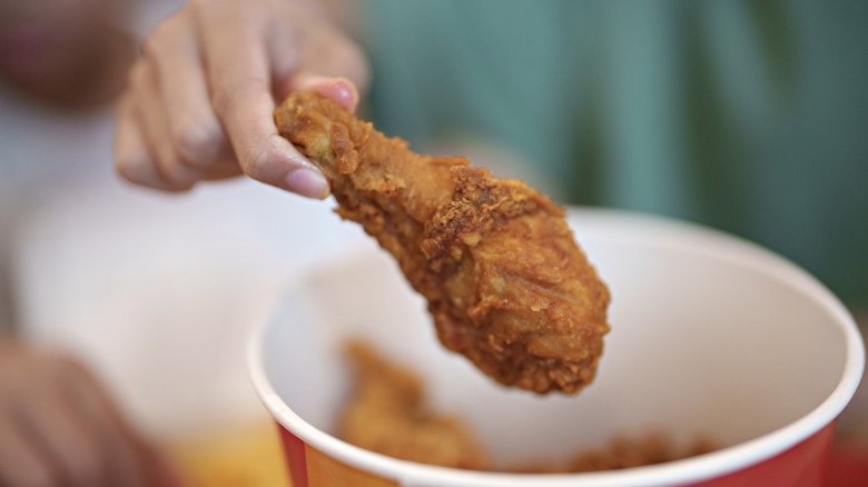 woman picking a drumstick from a bucket