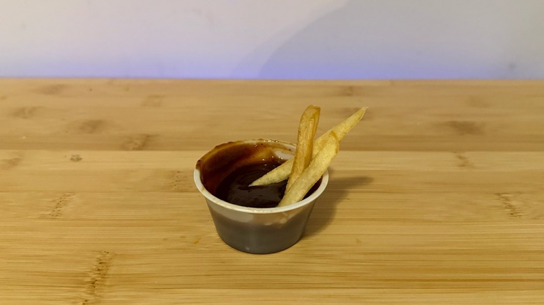 a close up of Smash burger barbecue sauce with some fries in it