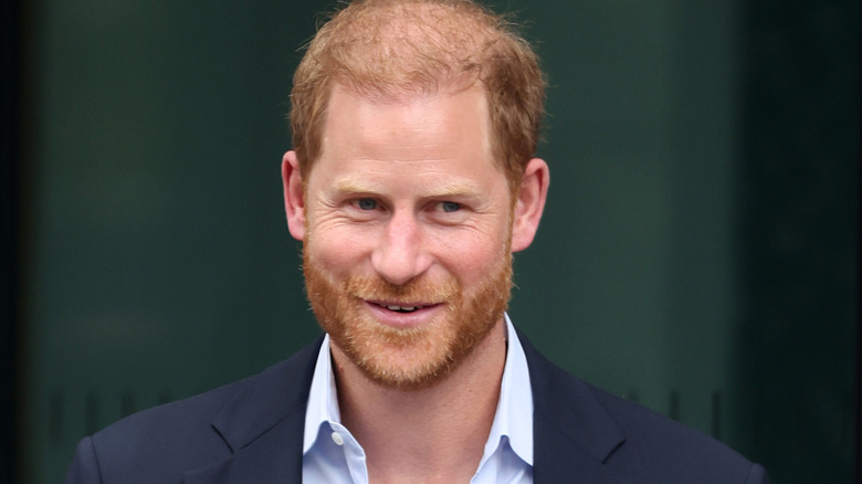 Prince harry smiling in navy blue blazer with button up