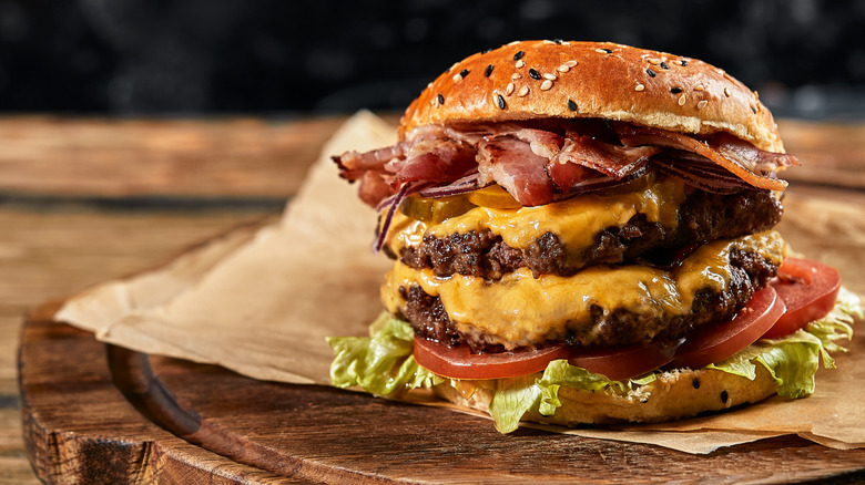 Large double bacon cheeseburger on wooden slab