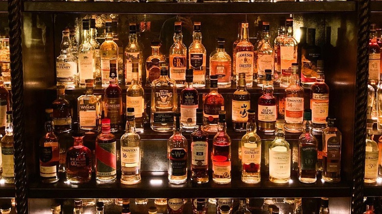 whiskey bottles lined up on shelves