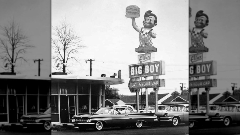 A black and white vintage photograph of a large Big Boy sign with the mascot
