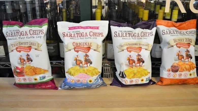Four bags of Saratoga Chips lined up in front of a wine cooler