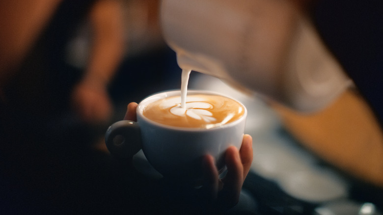 close up of barista pouring latte