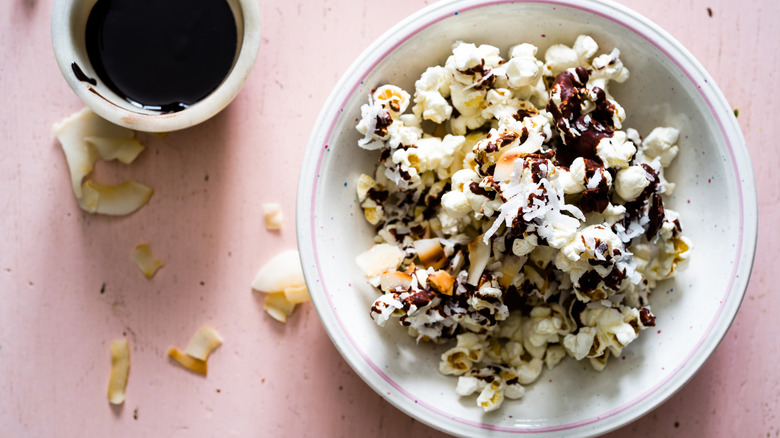 popcorn topped with chocolate drizzle and coconut flakes