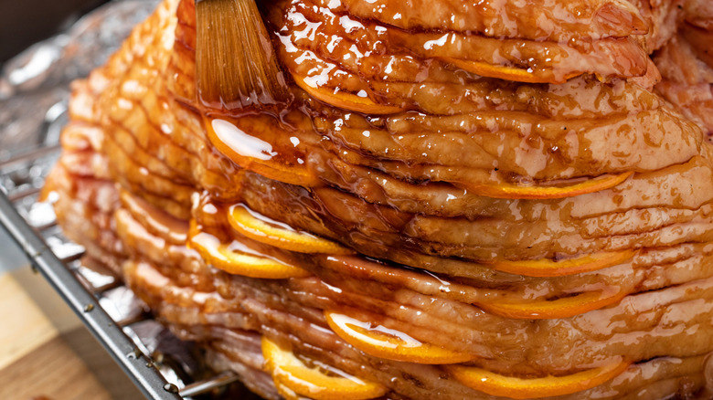 Slices of apples between ham splices being basted with marinade