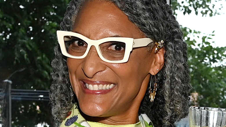Carla Hall smiling with white glasses