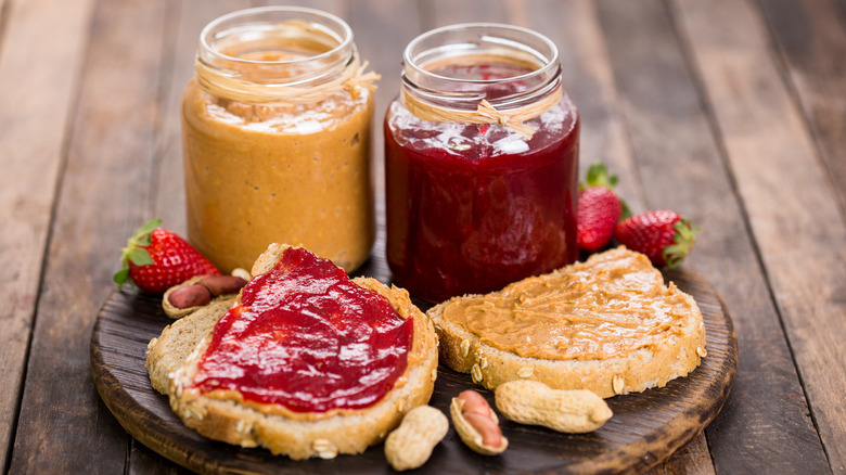 PB&J sandwich open with peanut butter and jelly jars