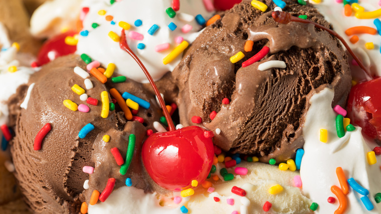 Chocolate and vanilla ice cream scoops with sprinkles, cherries
