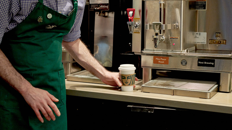 Starbucks worker serving coffee 