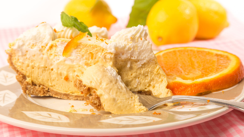 An slice of orange chiffon icebox pie with an orange garnish