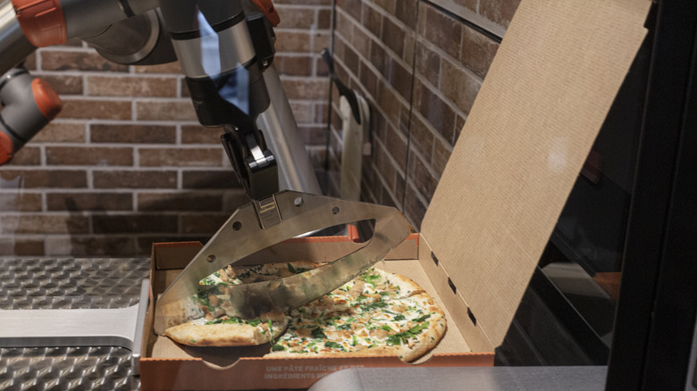 robot arm slicing pizza
