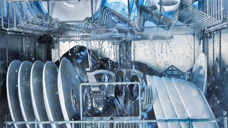 Interior of a fully loaded dishwasher during a wash cycle