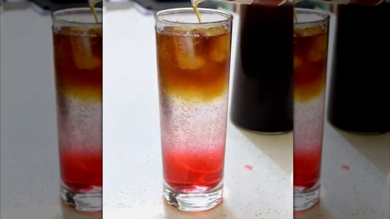A layered cranberry coffee tonic in a tall glass
