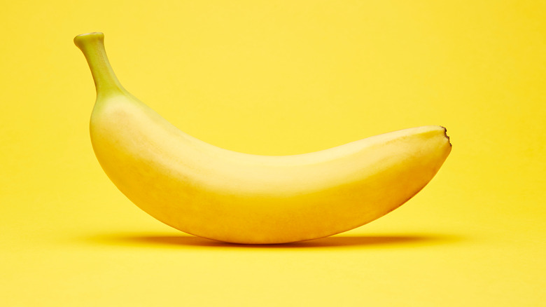 Single banana and yellow background