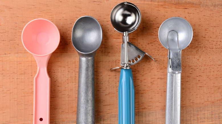 An array of different ice cream scoopers on a kitchen counter