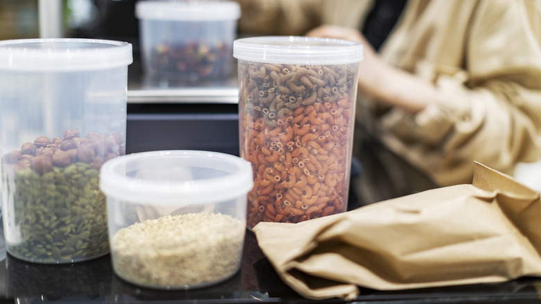 plastic deli containers holding pasta, seeds, and rice