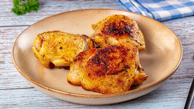 plate of crispy roasted chicken thighs with browned skin