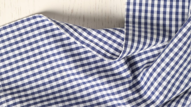 Blue checked tablecloth tossed on table with folds
