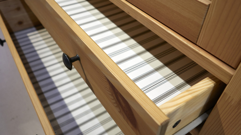 Two open drawers lined with striped fabric