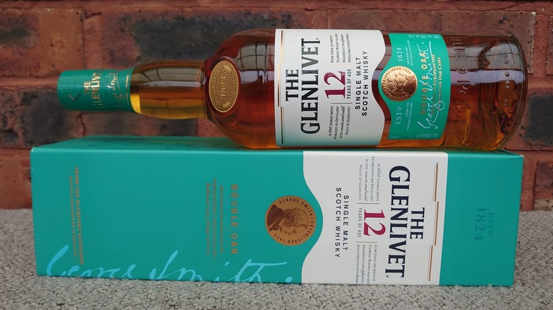 A bottle of The Glenlivet 12-year resting on its box in opposite directions