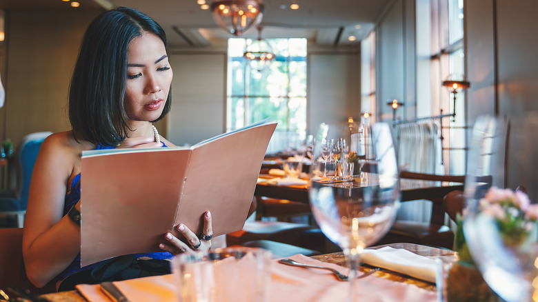 woman reading restaurant menu
