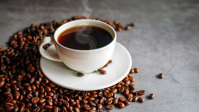 cup of coffee over coffee beans