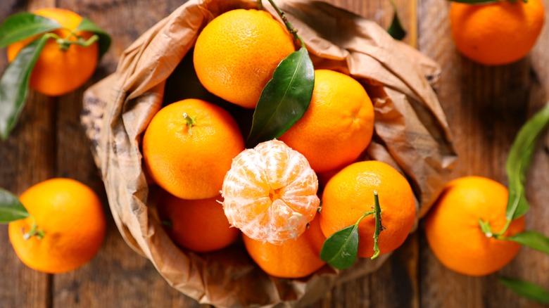peeled orange with oranges in rinds