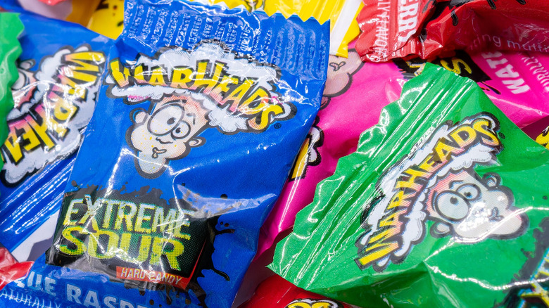 Neon blue, green, and pink bags of Warheads candies