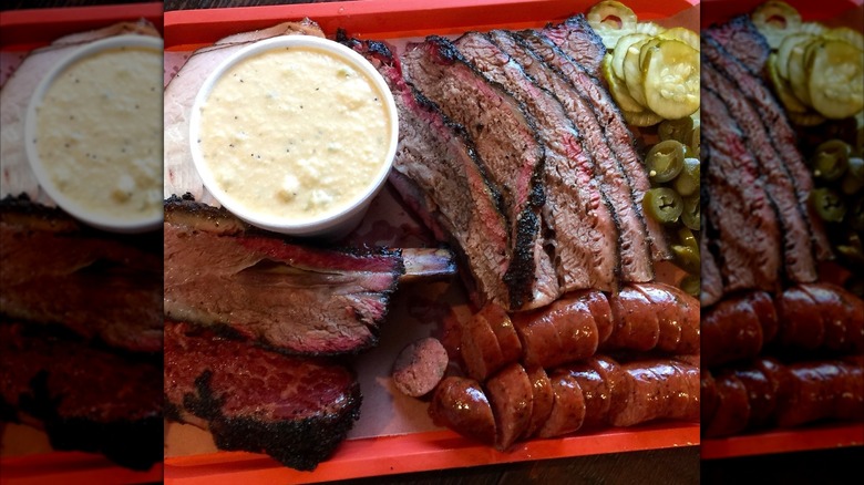 Red tray with sausages, brisket, and sides