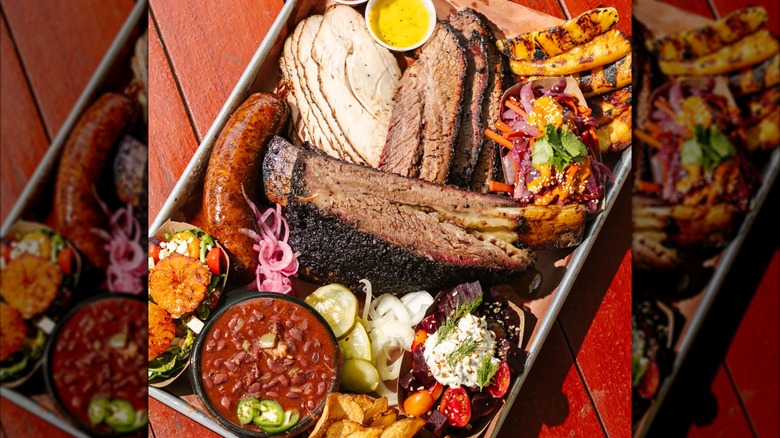 Tray of BBQ and sides, including turkey, brisket, and beans