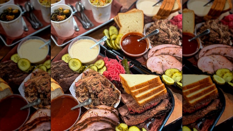 Assortment of BBQ meats, sides, bread, and sauces on trays